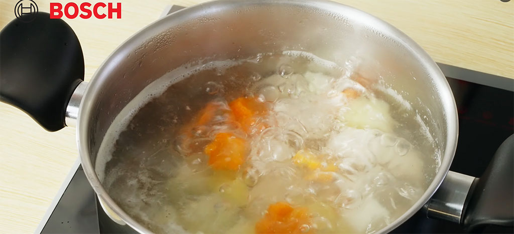 Nồi canh gà hầm rau củ Bosch đang sôi nhẹ, hơi nước lan tỏa, bọt được vớt sạch Nồi canh gà hầm rau củ Bosch đang sôi nhẹ, hơi nước lan tỏa, bọt được vớt sạch