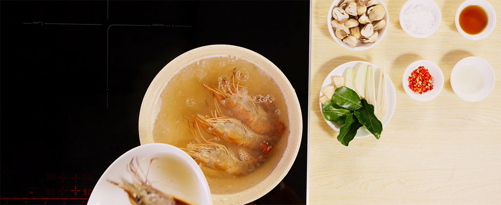 Nồi nước dùng trong veo đang sôi nhẹ trên bếp từ Bosch hiện đại Nồi nước dùng trong veo đang sôi nhẹ trên bếp từ Bosch hiện đại